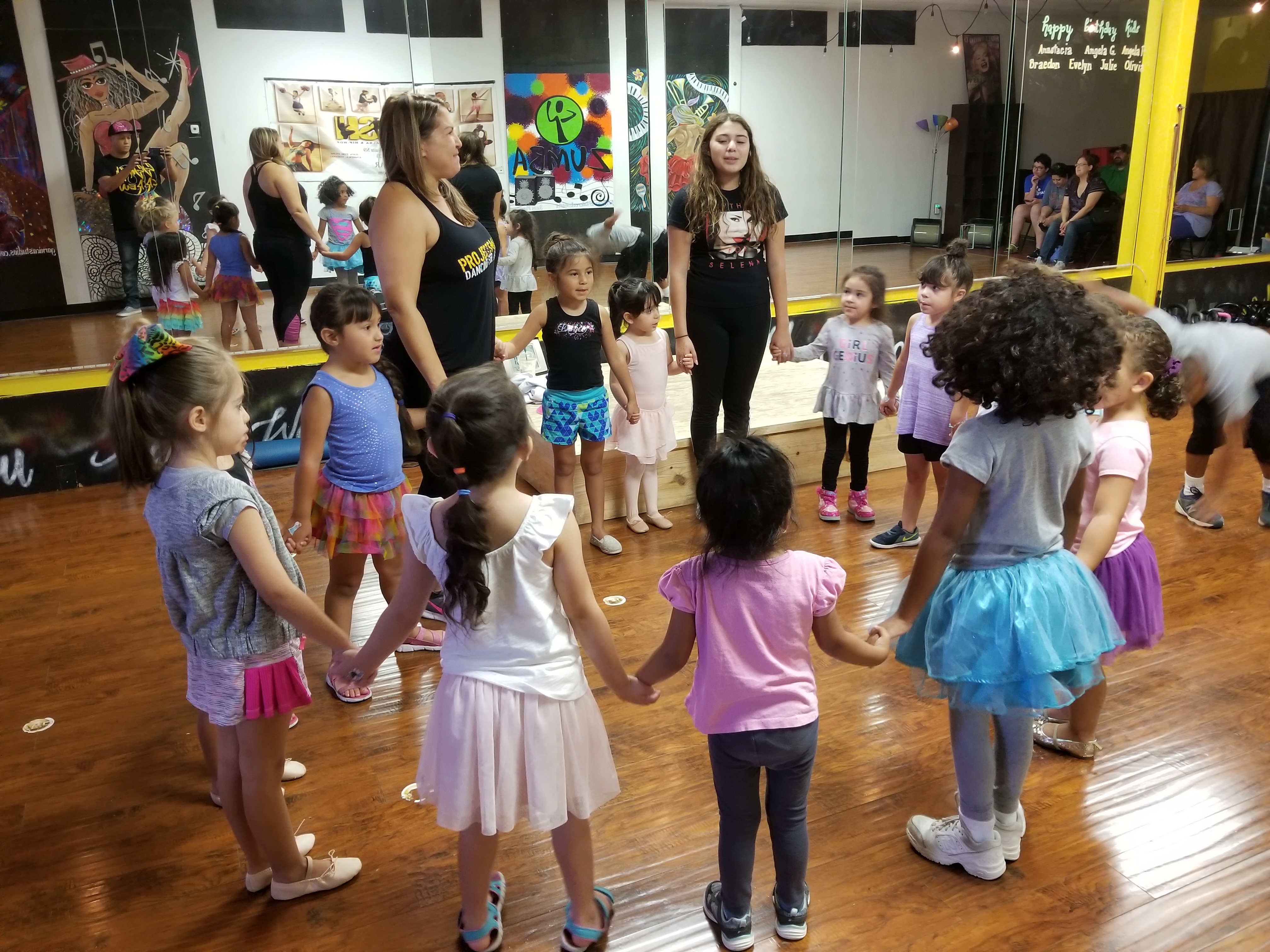 Tiny dancers holding hands in class